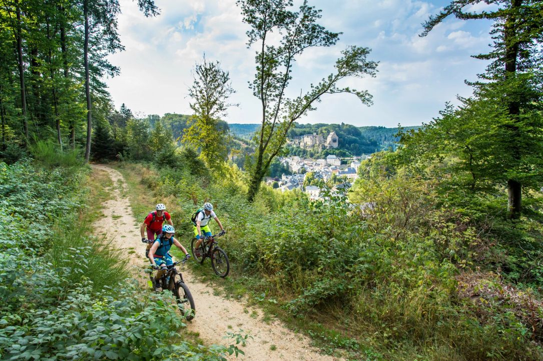 A group of mountain bikers ride through the forest of Larochette