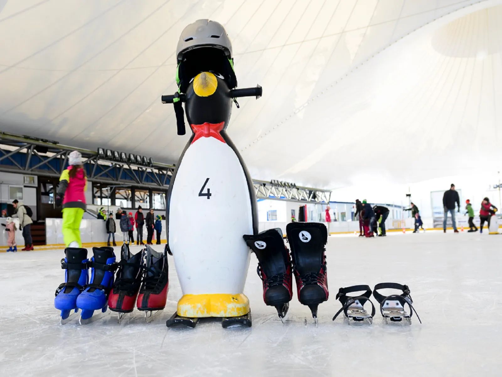 Schlittschuhe und Pinguin-Hilfsfigur fürs Schlittschuhfahren im Ice Park Beaufort
