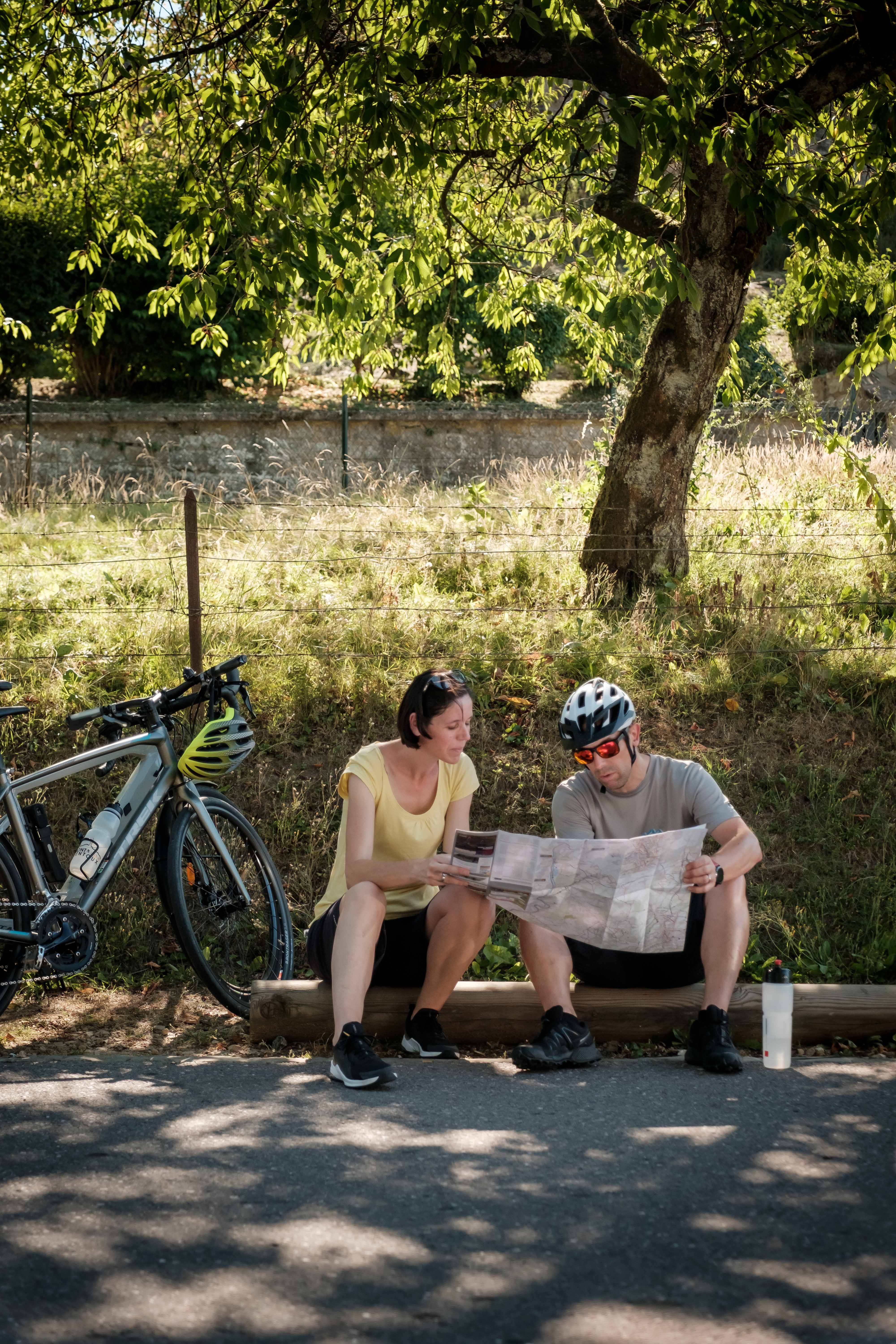 Zwei Radfahrer machen eine Pause und werfen einen Blick auf die Karte