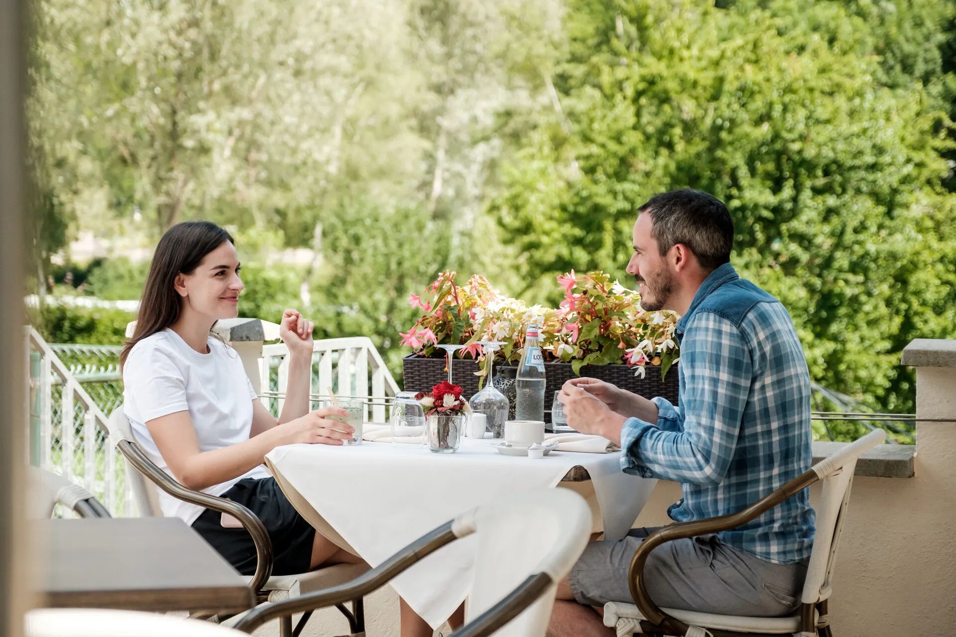 Zwei Personen sitzen zusammen am Tisch auf der Terrasse eines Restaurants