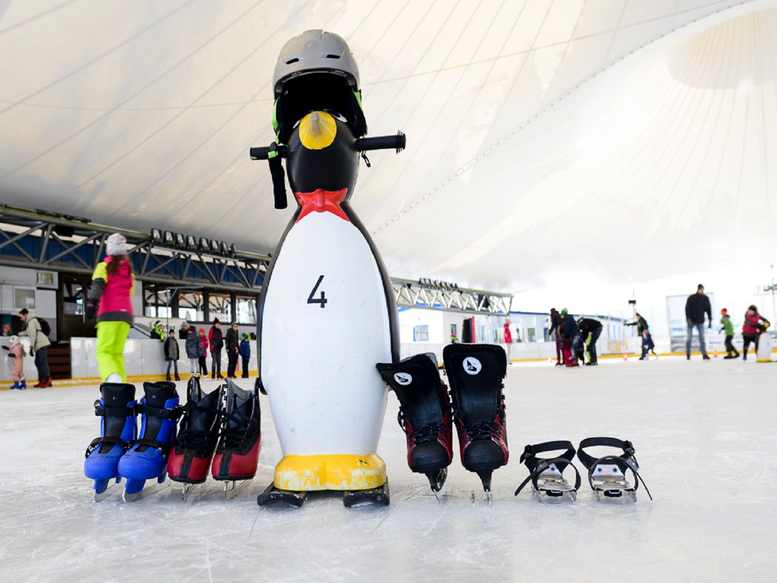 Schlittschuhe und Pinguin-Hilfsfigur fürs Schlittschuhfahren im Ice Park Beaufort