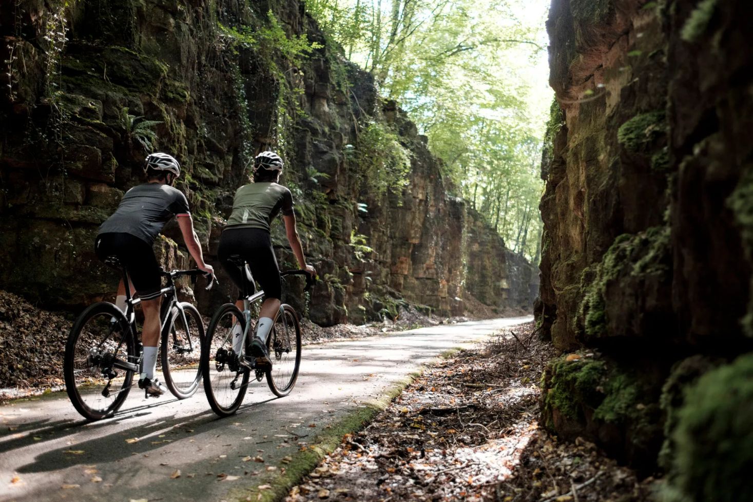 Deux cyclistes sur un chemin forestier avec des rochers