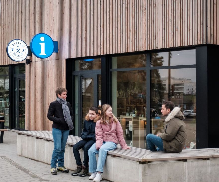 Une famille devant l'office du tourisme à Berdorf en hiver
