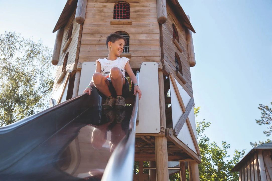 A child sliding down a slide at the playground in Rosport