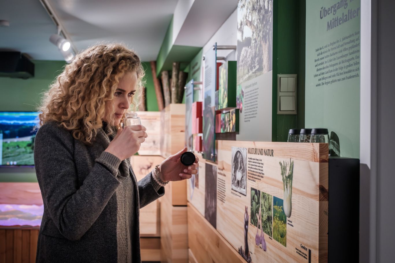 Frau liest eine Infotafel und riecht an einem Glas in der Geo-Expo in Beaufort.