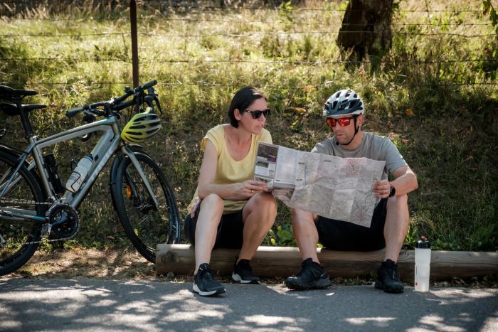Zwei Radfahrer machen Pause und werfen einen Blick auf die Karte