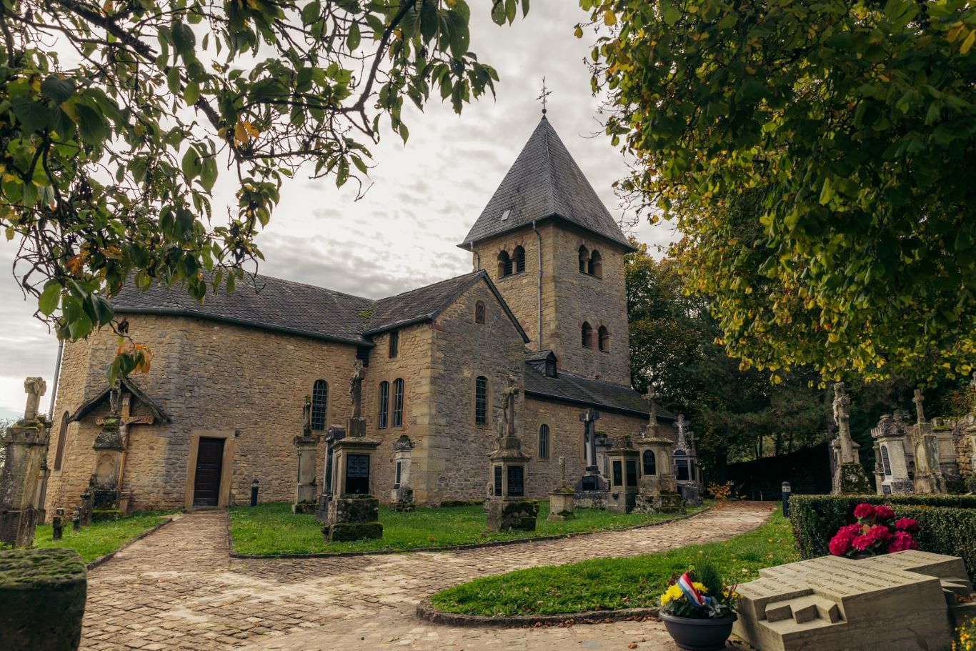 Chapelle de Girsterklaus avec cimetière et arbres.