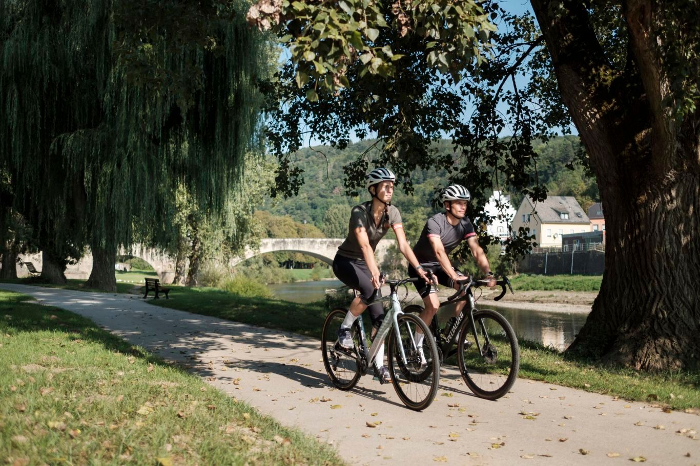 Twee fietsers rijden door Echternach park