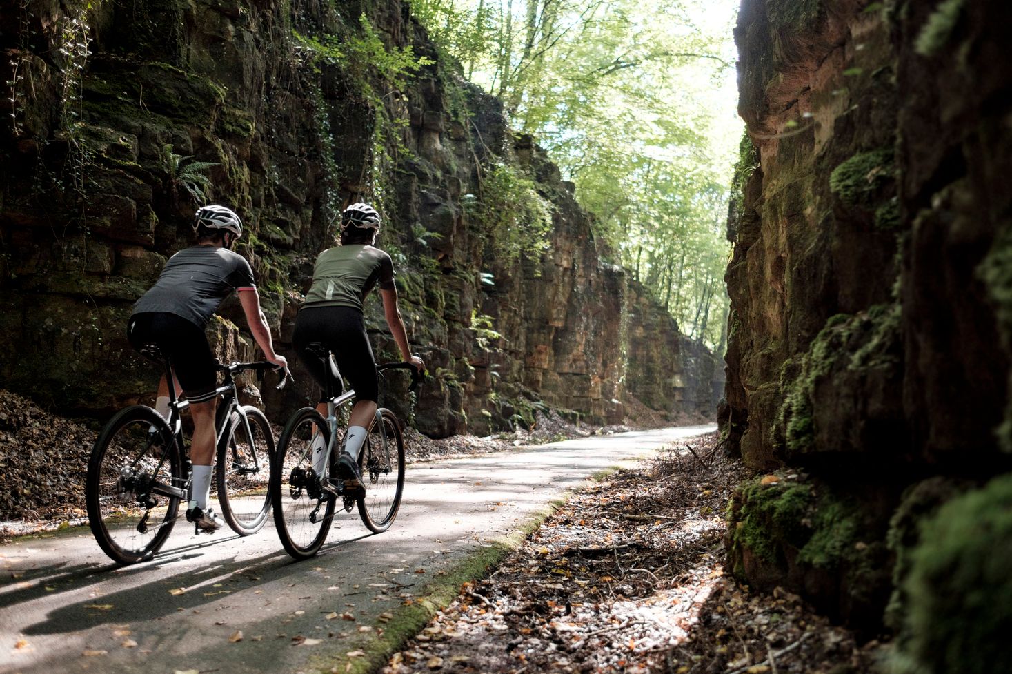 Deux cyclistes sur un chemin forestier avec des rochers