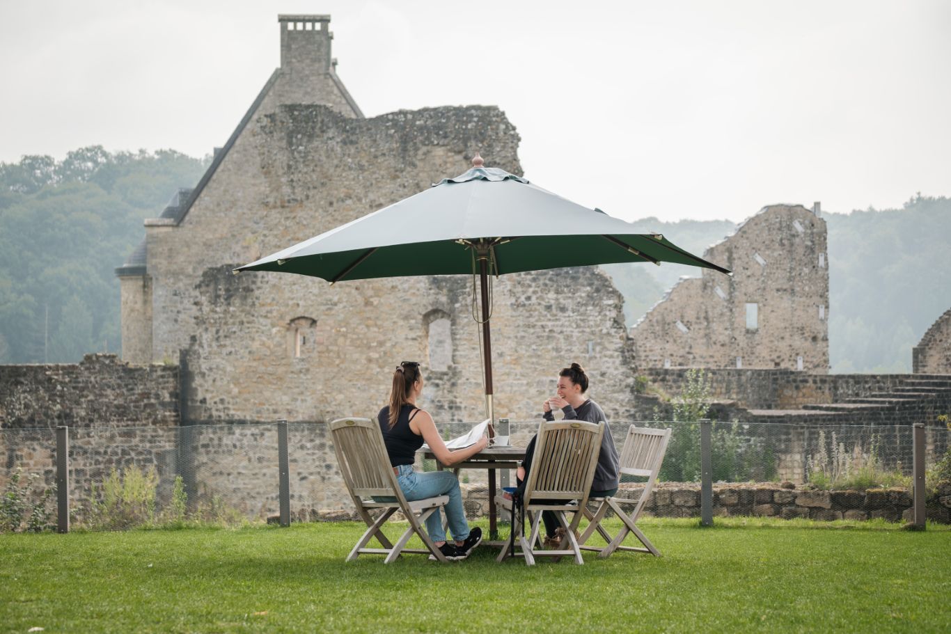 Entspannte Kaffeepause mit Aussicht auf die historischen Mauern von Schloss Larochette.