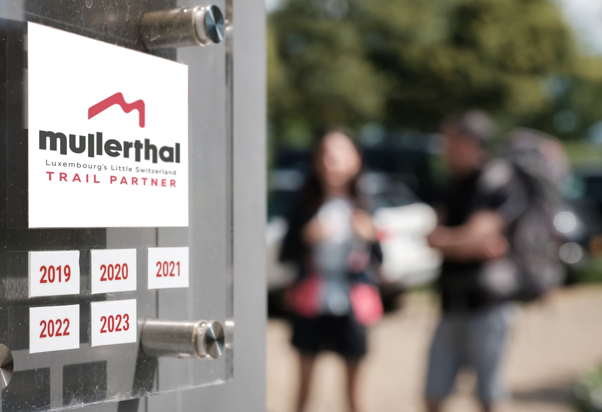 Distinction de partenaire du Mullerthal Trail devant un office de tourisme