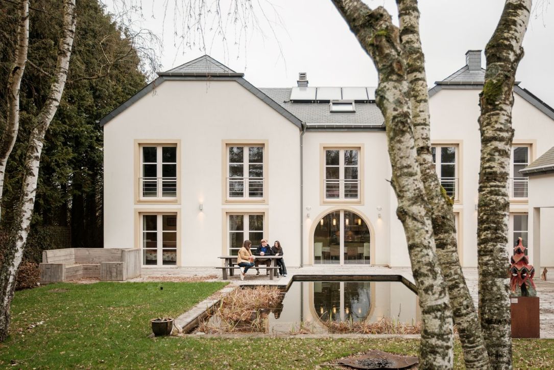 Drie personen zitten samen op de bank voor het B&B White Pearl