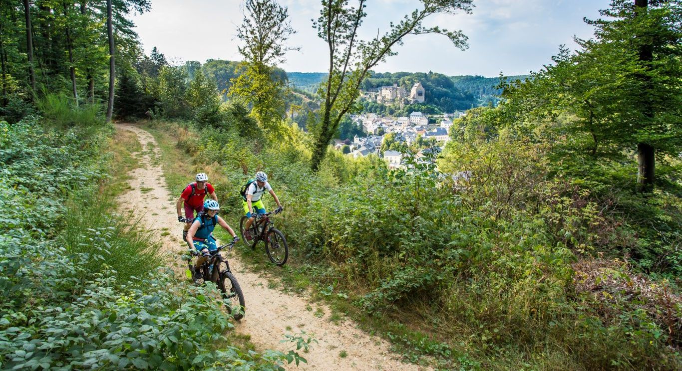 Een groep mountainbikers rijdt door het bos van Larochette