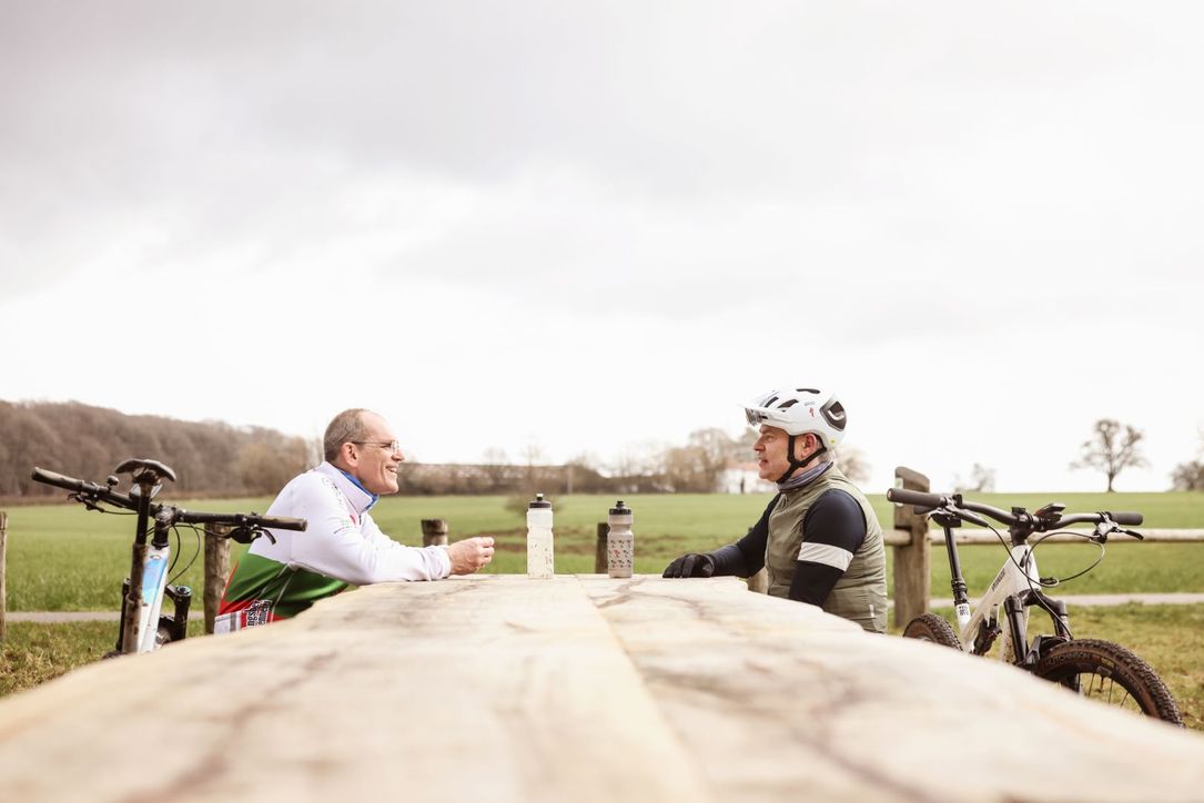 Twee fietsers maken een pauze op een bank