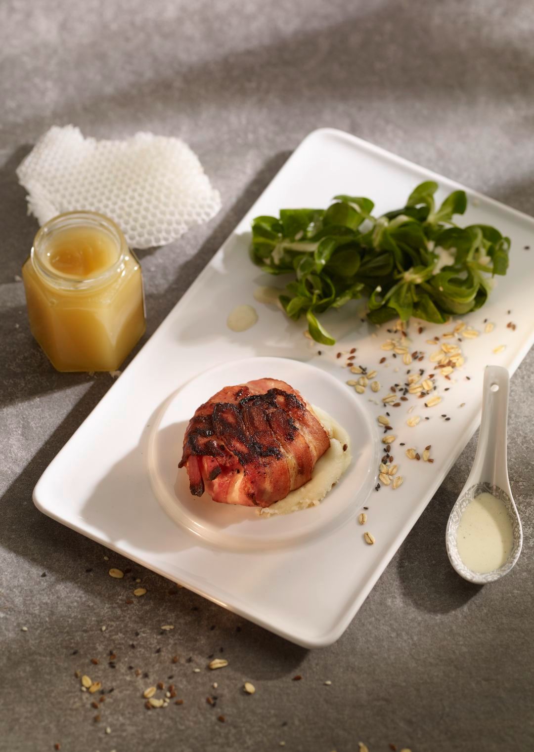 Plate with meat, salad, and a jar of honey