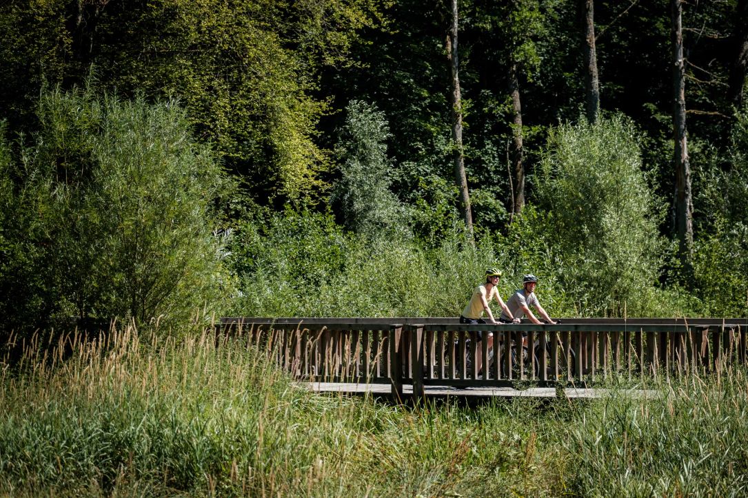 Two cyclists on a bridge along a cycling path